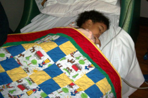 Child with one of Quilts For Kids donated quilts.